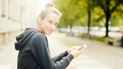 Young attractive woman using phone in city.
