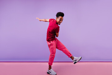 Full-length shot of trendy african male model in pink clothes. Excited black man in stylish...