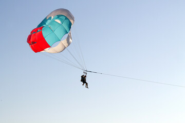 Paraglider soaring over the seashore