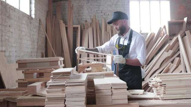 Carpenter working in his own woodshop with timber