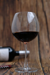 Red wine glasses and bottle on wooden table background, space for text