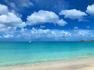 Fototapeta na wymiar tropical beach with blue sky and sailboat