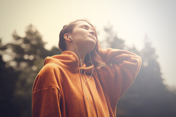 Hipster attractive girl in park using earphones