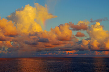 Naklejka na ściany i meble Rainbow shard and clouds at sunset over sea