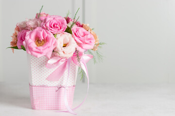 bouquet of beautiful pink roses and eustomas in a box on a white background. Floral gift for the holiday. place for text. horizontal image.