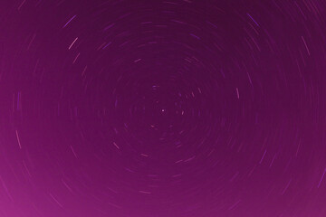 Background of round or circular star track or trajectory on the red, pink or rose clear night sky. Symbol of space, cosmos, expanse infinity and universe