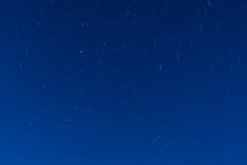 Background of round or circular star track or trajectory on the blue clear night sky. Symbol of...