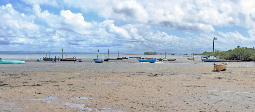 Mudflats, mangroves and fishing boats at low tide on the isle of Itaparica, Bahia, Brazil.