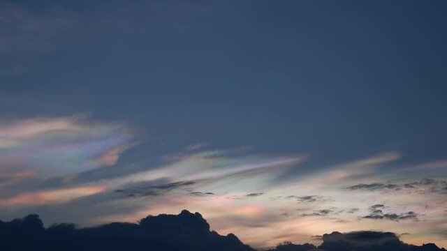 Time lapse motion The beauty of the rainbow clouds Above the black clouds moving fast on the sky in the evening.