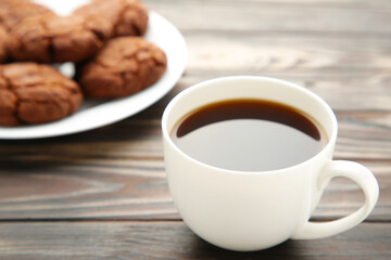 Cup of coffee and chocolate cookies on wooden table