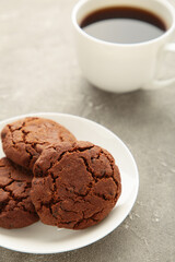 Cup of coffee and chocolate cookies on grey background. Top view