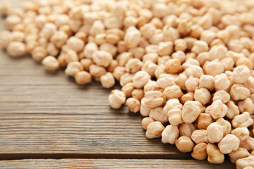 Dry raw organic chickpeas on grey wooden background.
