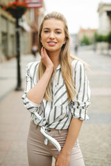 Fototapeta premium Portrait of beautiful young blonde woman in a city.