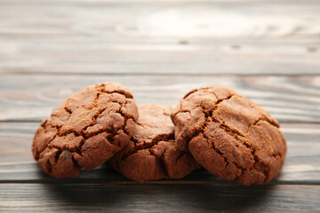 Chocolate chips cookies on brown wooden background.