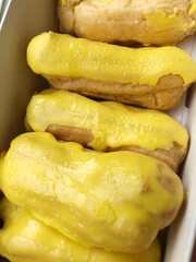 Delicious eclairs with yellow glaze in a box