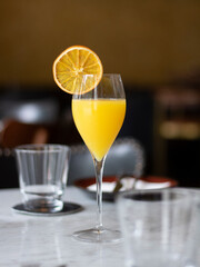 Orange Cocktail at a Bar. Yellow Cocktail at a Restaurant. Mimosa Cocktail on Dark Background.