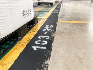 Line and number on the floor which use to identify the location of pallet inside of the warehouse. Warehouse management, industrial concept.