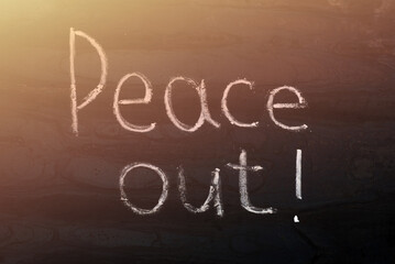 lettering made in chalk on a metal board - peace out