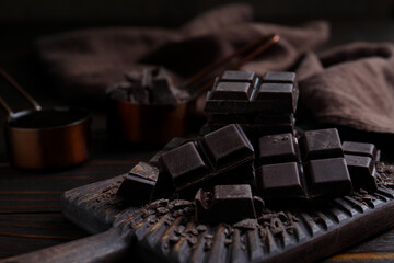 Delicious dark chocolate on wooden board, closeup