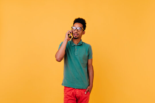 Serious Black Guy Talking On Phone. Studio Portrait Of Curly African Boy Calling Someone.