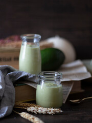Avocado Smoothies Rustic Setting. Avocado Milkshake on Dark Background with Copy Space. Rustic Avocado Juice.