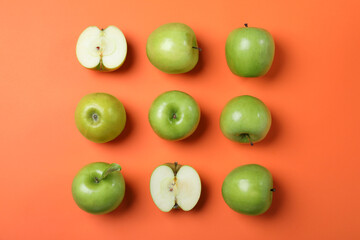 Tasty green apples on orange background, flat lay