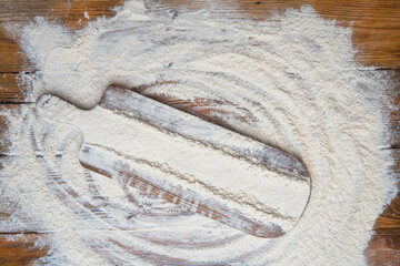 White flour on old rustic wooden table, top view. Baking background with free space for your text.