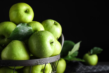 Fototapeta na wymiar Juicy green apples in metal basket on black background, closeup