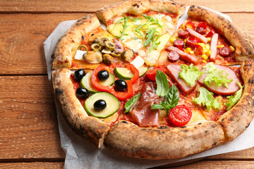 Slices of different delicious pizzas on wooden table, closeup