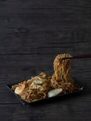 Singapore Bee Hoon (Vermicelli Noodles) on Dark Background with Copy Space. Bee Hoon on Chopsticks.