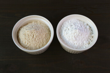 Bowl of Whole-wheat Flour and A Bowl of White Flour Isolated on Dark Brown Wooden Table