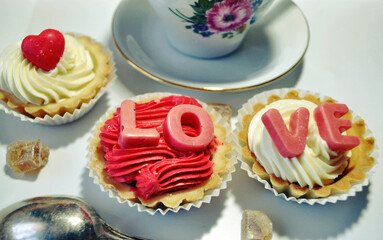 Romantic breakfast. Cupcakes with LOVE letters and green tea cup. Valentines Day, Mother's day, March 8. Love, romantic background