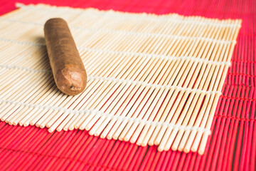 Luxurious cigar on dinner bamboo mat.