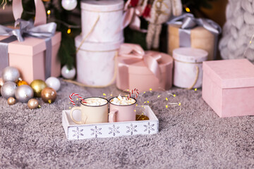 Two cups with cappuccino, a festive box with a gift, Christmas decorations