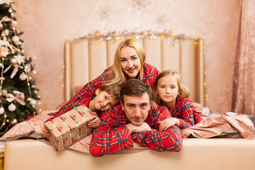 cheerful family lying down near Christmas tree at home