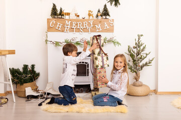 Boy and girl playing with christmas present box in beautiful room.