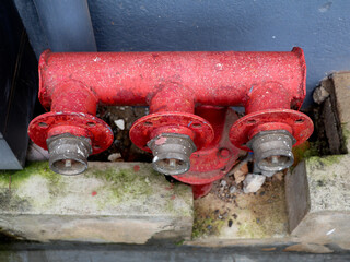 Red color fire extinguisher valves at the bottom of the wall