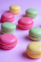 Colorful macaroons on pastel background from above. Vertical photo