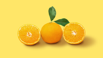 Orange fruit and ripe half of orange fruit on yellow background