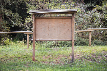 wooden billboard in a natural park, empty board for advertisement in natural scenery