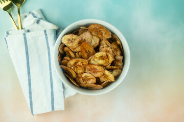 Homemade dehydrated banana chips cuisine fried in hot oil baked.