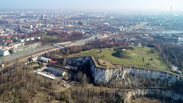 Krakus Mound in Krakow, Poland. The origin of the mound, probably early medieval kurgan, is not known. Old quarry in front. City panorama in the background. Aerial 4K video