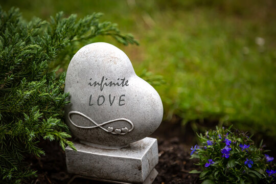 Ein Herz mit der Aufschrift "infinite Love" mit einem "Unendlich"-Zeichen auf einem Marmorsockel auf einem Grabstein