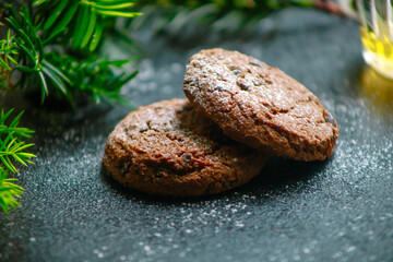 Christmas cookies with chocolate in powdered sugar coniferous branch on the table