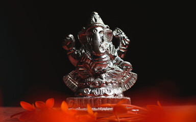 Ganesha / Ganapathi idol decorated with flowers and interesting background for Ganesh Chaturthi