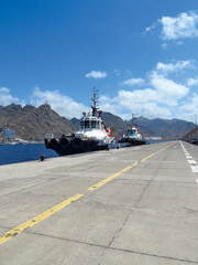 Perspective view of tug boat docked at port dock. Professional boat for port work. Large tugboat...
