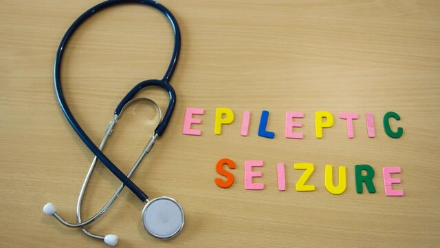 stop motion time lapse of word with colorful epileptic seizure letters on a table with a stethoscope and moving medicines