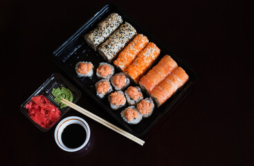 Delivery of Japanese food home. A finished set of sushi rolls on a black background.