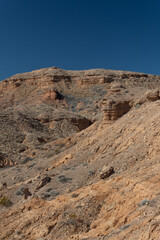 Deep blue sky above a series of inclines in the New Mexico desert, travel in the USA, creative copy space, vertical aspect