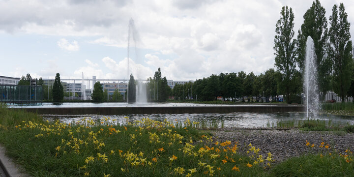 Munich, Bavaria / Germany - July 12, 2020: „Riem Arcaden“, a modern shopping mall with different retail shops, gastronomy and offices, in the foreground a pond with fountains and waterlilys